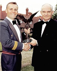 Sqn Ldr Dave Hughes, SATCO at RAF College Cranwell, receives the Raytheon Falconer Trophy from Mr. Peter Robbie, Sales and Marketing Manager, Raytheon Systems Limited